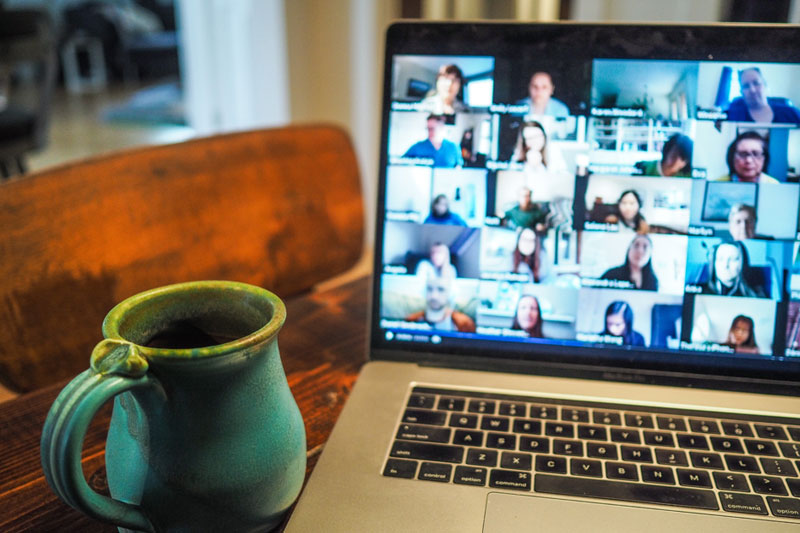 laptop with video meeting on the screen, showing remote work